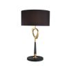 A contemporary table lamp by Eichholtz with a stylish design featuring an antique brass finish, an open free shape and a black cylindrical shade