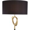 A contemporary table lamp by Eichholtz with a stylish design featuring an antique brass finish, an open free shape and a black cylindrical shade