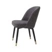 A trendy and chic pair of upholstered dining chairs with a curved back, black legs and brass feet