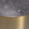 A contemporary side table with a grey marble top and brushed brass finish