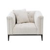 A luxurious armchair by Eichholtz with a square shaped design featuring a Lyssa off-white upholstery, deep buttoned stitching and a black gunmetal base