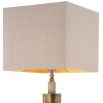 A stylish table lamp by Eichholtz with a structural design, stainless steel composition and vintage brass finish