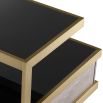 A sophisticated side table by Eichholtz which doubles up as a stylish storage solution with a brass frame and black glass finish