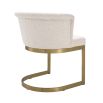 Modern, boucle upholstered dining chair with brushed brass base