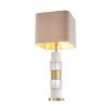 A stylish table lamp by Eichholtz featuring a luxury linen mix shade and marble, crystal glass base with an antique brass finish 