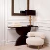 The Spring Console Table, crafted from mocha oak veneer and brushed brass, combines an elegant hourglass shape with a sleek, contemporary design.