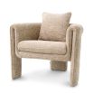 A curvaceous armchair with a contemporary chic upholstery and complementary scatter cushion
