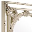 An elegant wall mirror by Eichholtz embellished with delicate leaves and blossoms with an antique white finish