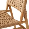 A stylish set of outdoor dining chairs by Eichholtz with intricate woven patterning and a teak wood finish