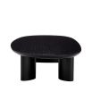 A sophisticated coffee table by Eichholtz with playfully asymmetrical legs and a beautiful black finish