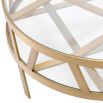 Circular coffee table with geometric brass legs and glass top