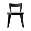 A rattan base dining chair with tapered legs and black frame
