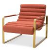 orange linen upholstered armchair with horizontal fluting and brass frame