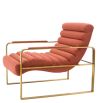 orange linen upholstered armchair with horizontal fluting and brass frame