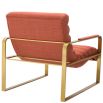 orange linen upholstered armchair with horizontal fluting and brass frame