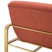 orange linen upholstered armchair with horizontal fluting and brass frame