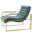 blue linen upholstered armchair with horizontal fluting and brass frame