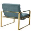 blue linen upholstered armchair with horizontal fluting and brass frame