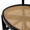 A stylish counter stool by Eichholtz with a black composition and rattan seat