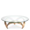Curvaceous trio-legged coffee table in brass with round glass top