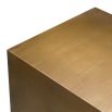 Modern side table with two curved legs finished in brushed brass