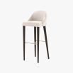 A luxurious bar stool with a luxury upholstery and wooden legs with metallic details