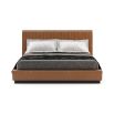 A luxurious leather bed with a fluted headboard and a wrought iron plinth
