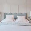 A luxurious velvet bed with a sculptural, coastal-inspired ripple headboard