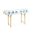 A futuristic white console table with blue acrylic cabochons and a polished brass base 