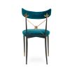 A luxurious vintage-style dining chair with polished brass accents and navy upholstery