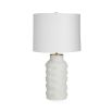 A luxurious porcelain lamp with polished brass accents and a white paper shade