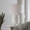 A modern side lamp with a textured white ceramic base and luxury linen shade