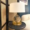 A luxurious crystal glass table lamp with a brushed brass base