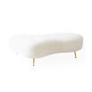 Organic shaped upholstered ottoman with tapered brass legs