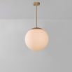 Industrial style glass globe pendant made entirely of solid brass and handblown glass globes with a natural brass finish