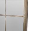 A large leaning mirror with an antiqued design featuring a bevelled mirror and champagne gold, hand-painted wood finish