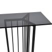 Black metal console table with geometric legs and tinted glass top