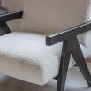Minimal boucle upholstered armchair with black armrests