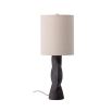 A bold, brutalist inspired table lamp made from terracotta with a linen shade