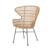 A luxurious woven rattan armchair with metal legs
