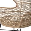 A luxurious woven rattan armchair with metal legs