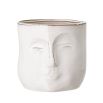 A glazed ceramic handcrafted flowerpot with abstract human facial features