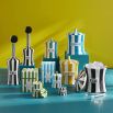 A glamorous candle by Jonathan Adler with a blue and brass finished peace vice canister