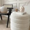 A luxurious boucle cream upholstered ottoman with storage space