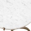 A stylish white marble dining table with a hammered antique brass base