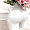 a white vase featuring a feminine bottom