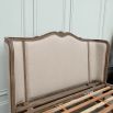 French-style bed with light wooden and linen frame 
