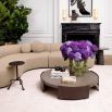 Round coffee table with wooden surface suspended between bronze legs