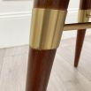 A luxurious, velvet dining chair with walnut wood and brass detailed legs.