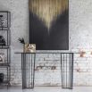 Black metal console table with geometric legs and tinted glass top